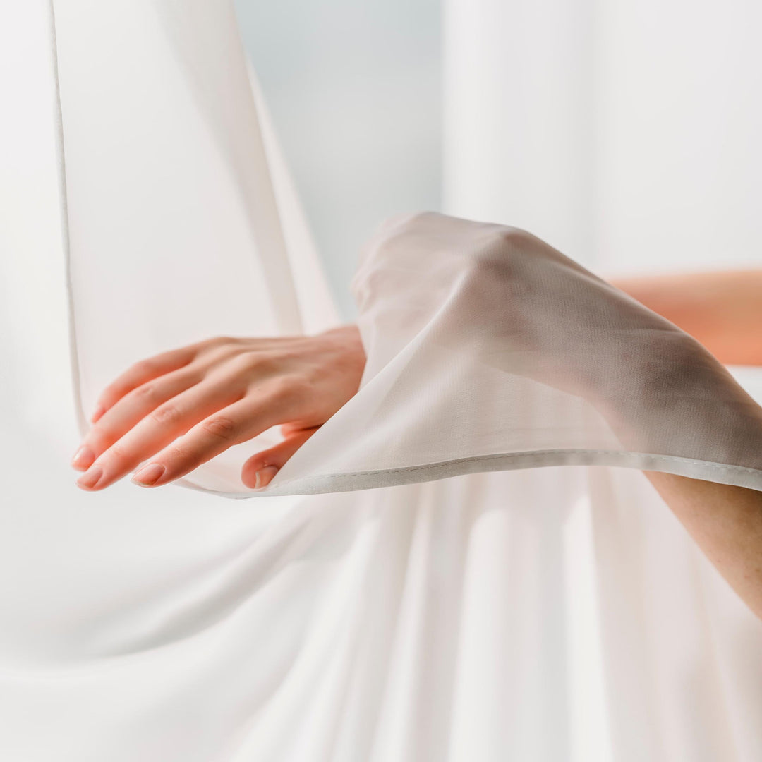 hands touching soft, lightweight, sheer gossamer fabric for summer beachwear