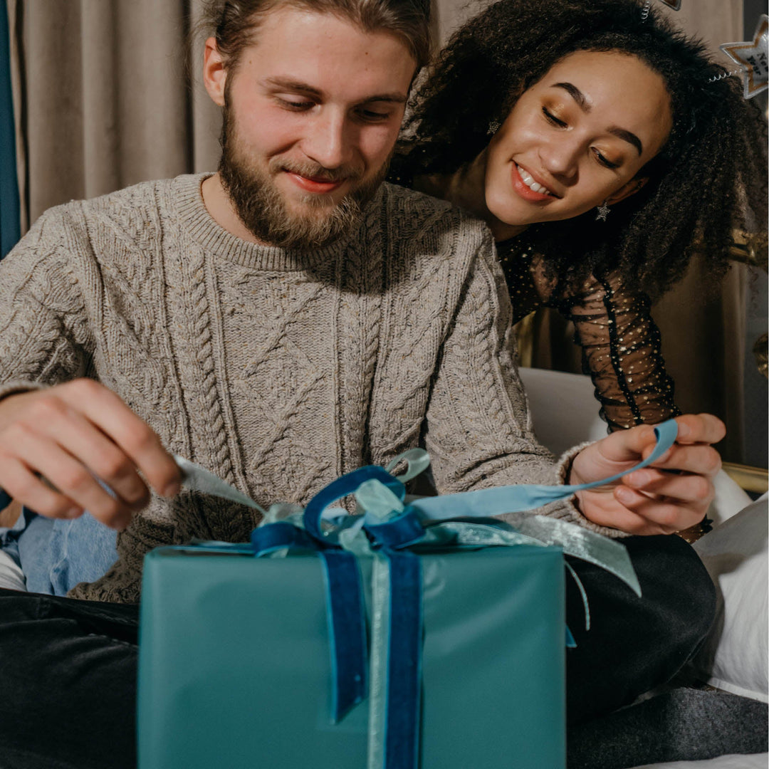 woman surprising man with a gift of hawaiian clothing for men